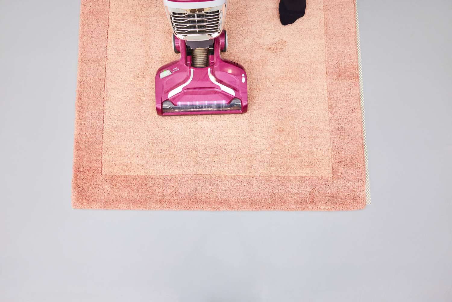 A person vacuums the GreenRow Rhodes Solid Rug