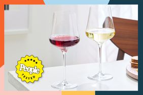 glass of red wine and glass of white wine on white table with colorful border around image and people tested badge
