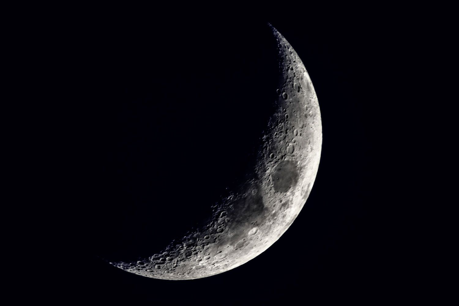 Close-up horizontal view of a new moon in a black sky in detail