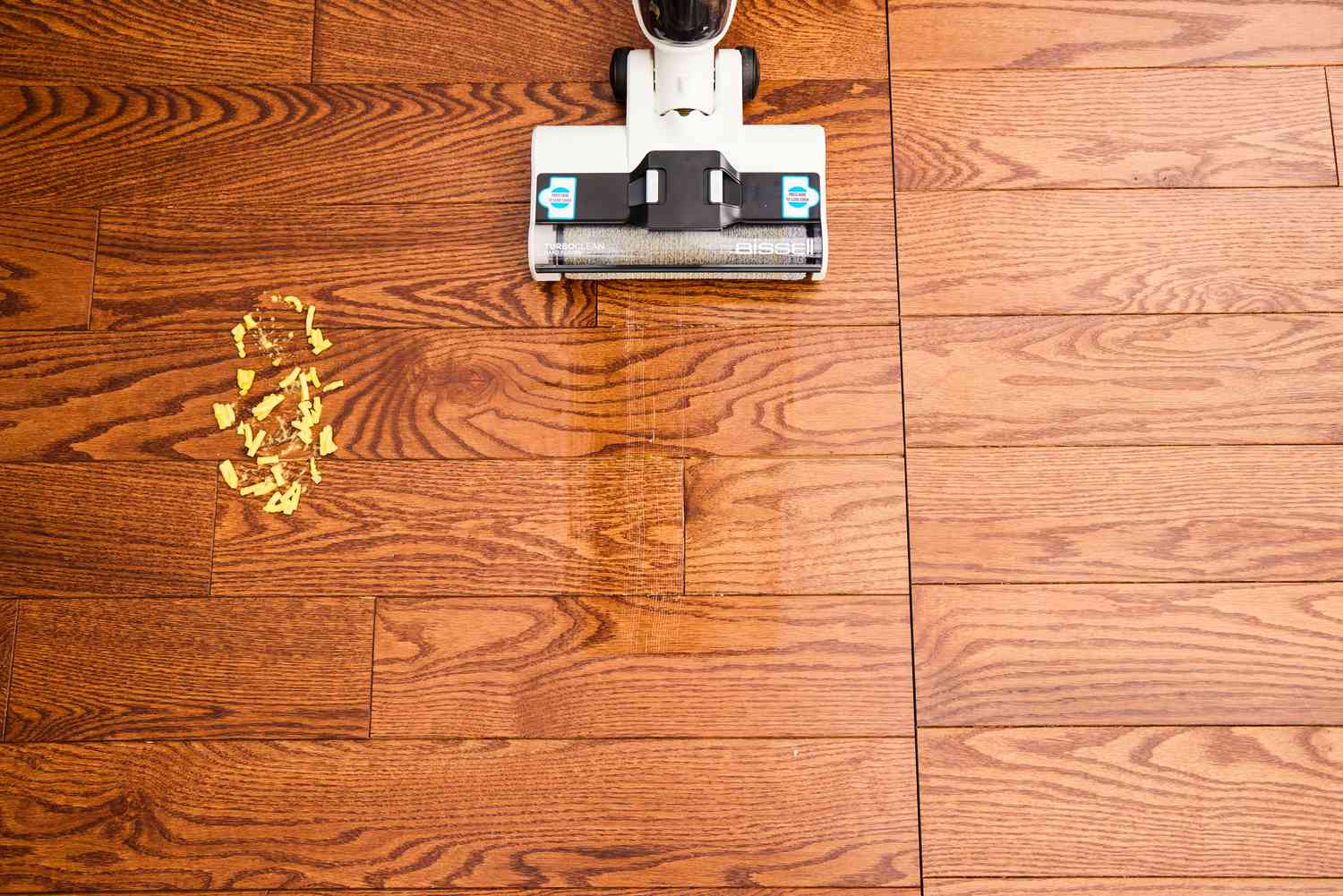 The Bissell TurboClean Cordless Hard Floor Cleaner is used to clean a hardwood floor