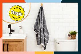 The Cacala Turkish Bath Towel handing on a bathroom wall with a colorful border and People Tested badge