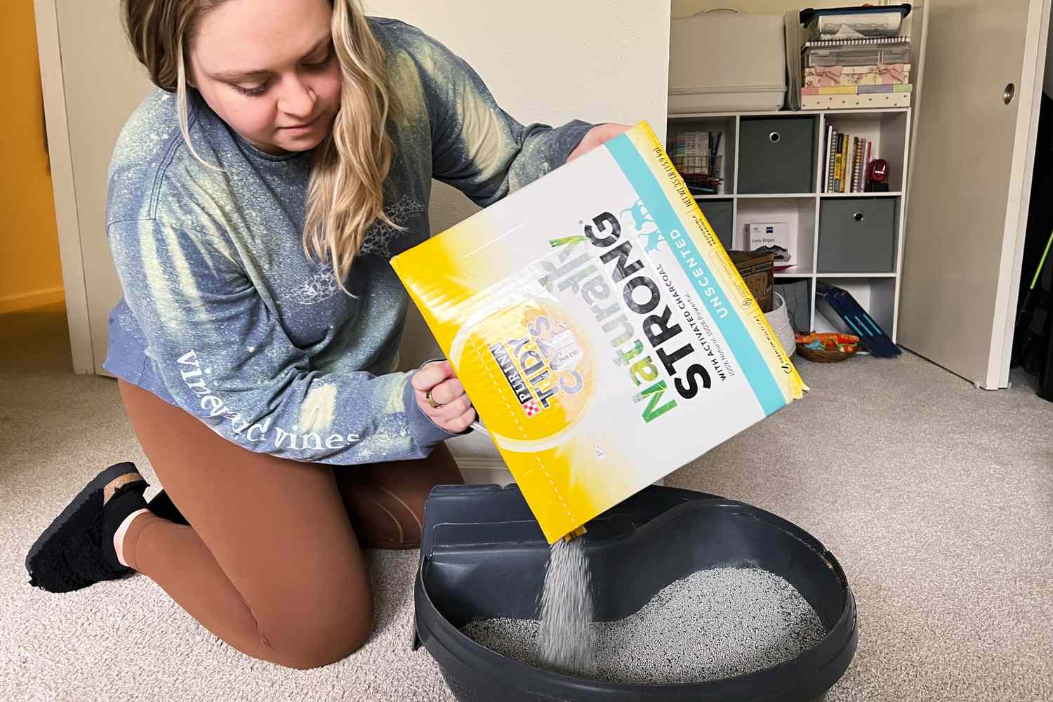 Person pouring Purina Tidy Cats Naturally Strong Unscented Cat Litter into a litter box