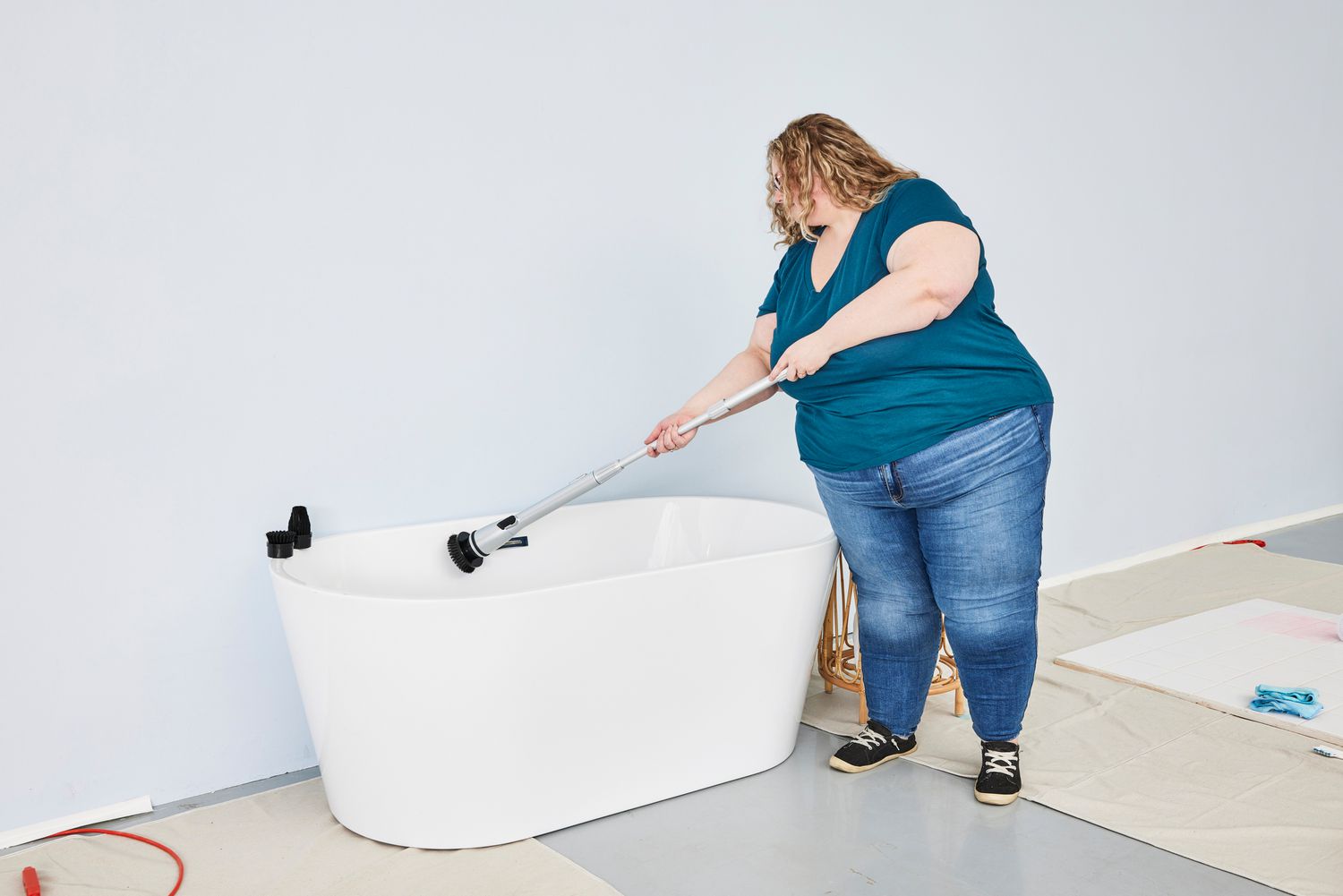 Person cleans a white tub with a HattyRoom Rechargeable Cordless Electric Spin Scrubber