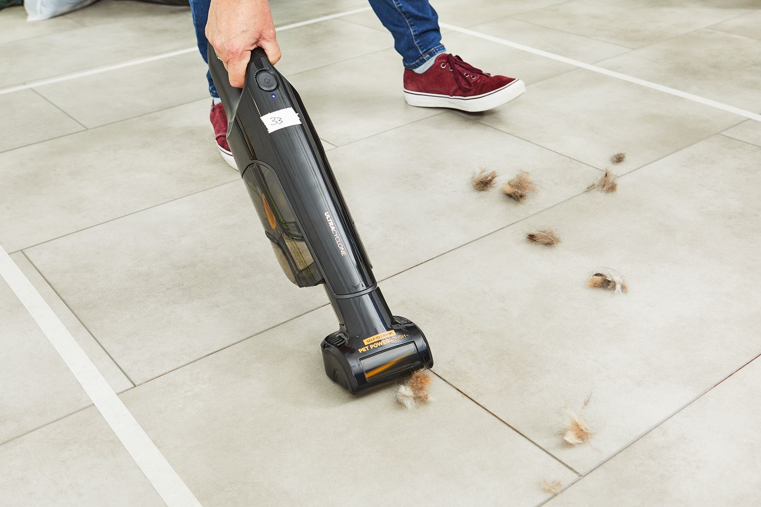 Shark UltraCyclone Pet Pro+ Cordless Handheld Vacuum used to clean the dust on the tile floor