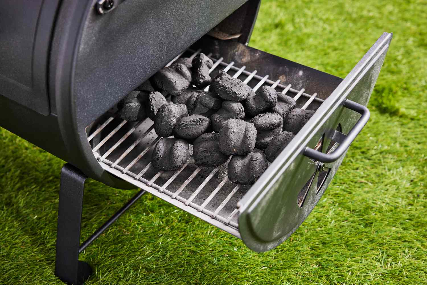 tray of coal pulled out from bottom of Char-Griller Portable Charcoal Grill and Side Firebox 