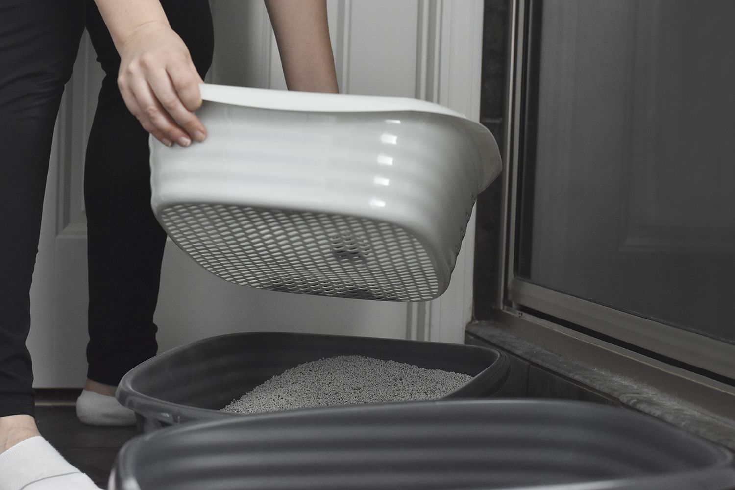 Hands lifting the sifter from the Arm & Hammer Sifting Litter Box