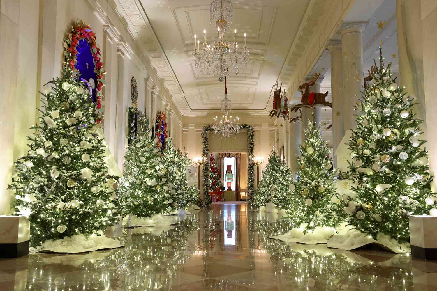 The Cross Hall between the East Room and the State Dining Room is lined with frosted Christmas tress during a media preview of the 2023 holiday decorations at the White House November 27, 2023