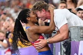 Gold medallist US' Tara Davis-Woodhall (L) celebrates with her husband US' track and field paralympic athlete Hunter Woodhall (R) after winning the women's long jump final of the athletics event at the Paris 2024 Olympic Games at Stade de France in Saint-Denis, north of Paris, on August 8, 2024.