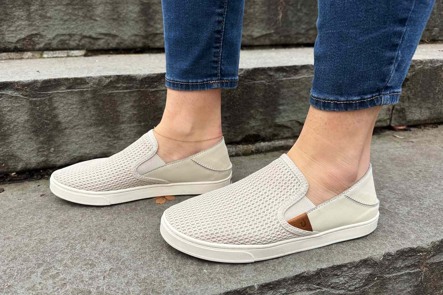 Person wearing OluKai Pehuea Slip On Sneakers while walking up steps