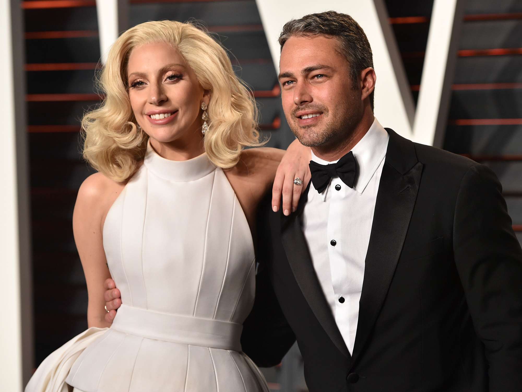 Lady Gaga (L) and Taylor Kinney arrive at the 2016 Vanity Fair Oscar Party Hosted By Graydon Carter at Wallis Annenberg Center for the Performing Arts on February 28, 2016 in Beverly Hills, California