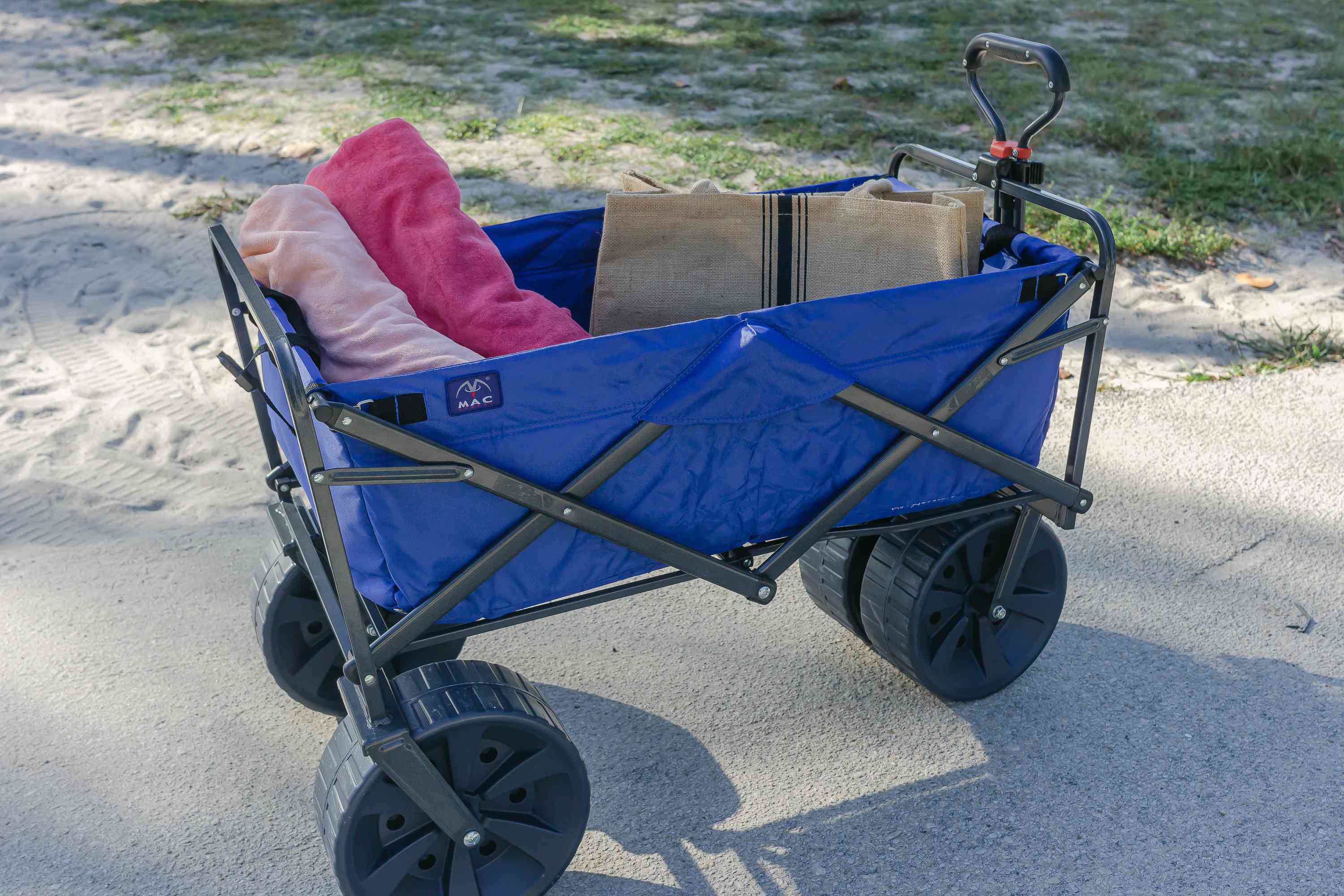 Closeup of Mac Sports Heavy Duty Collapsible Beach Wagon filled with supplies displayed on paved pathway