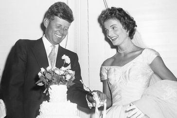 John F. Kennedy and Jacqueline Lee Bouvier cut their wedding cake.