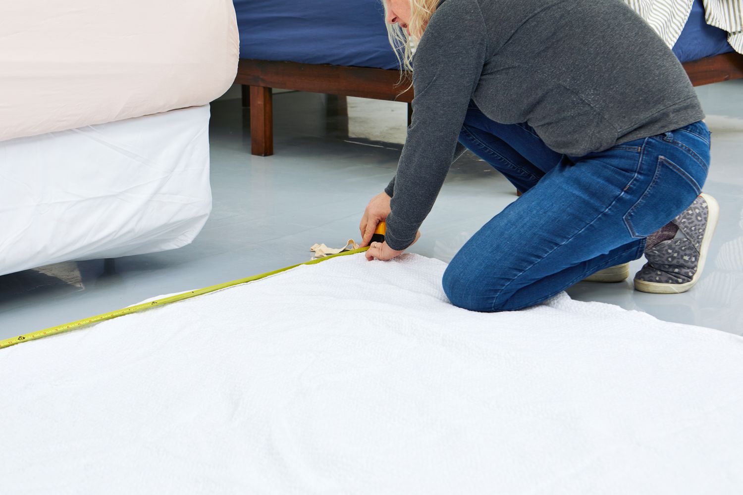 Person using measuring tape to measure the Quince European Linen Duvet Cover on the floor 