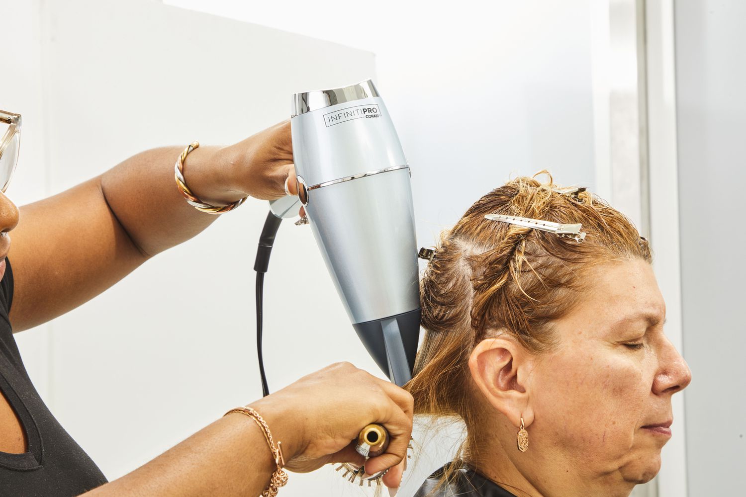 Closeup of a person blowdrying another person's hair with Conair InfinitiPRO SmoothWrap Hair Dryer