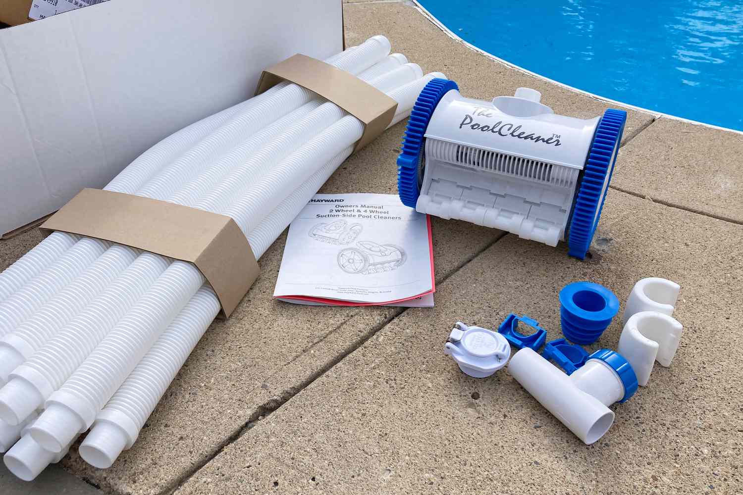 Hayward The PoolCleaner 2-Wheel Suction Cleaner unboxed next to a pool