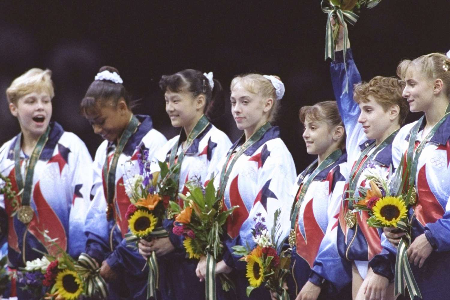 Injured Kerri Strug, bandaged leg, joins the gymnastics team from the USA with their gold medal for the team gymnastics event at the Georgia Dome at the 1996