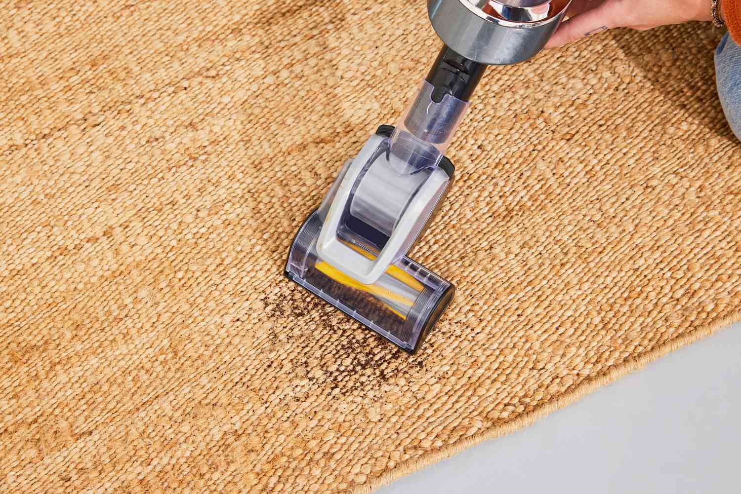 A person vacuums the Revival Hart Jute Rug