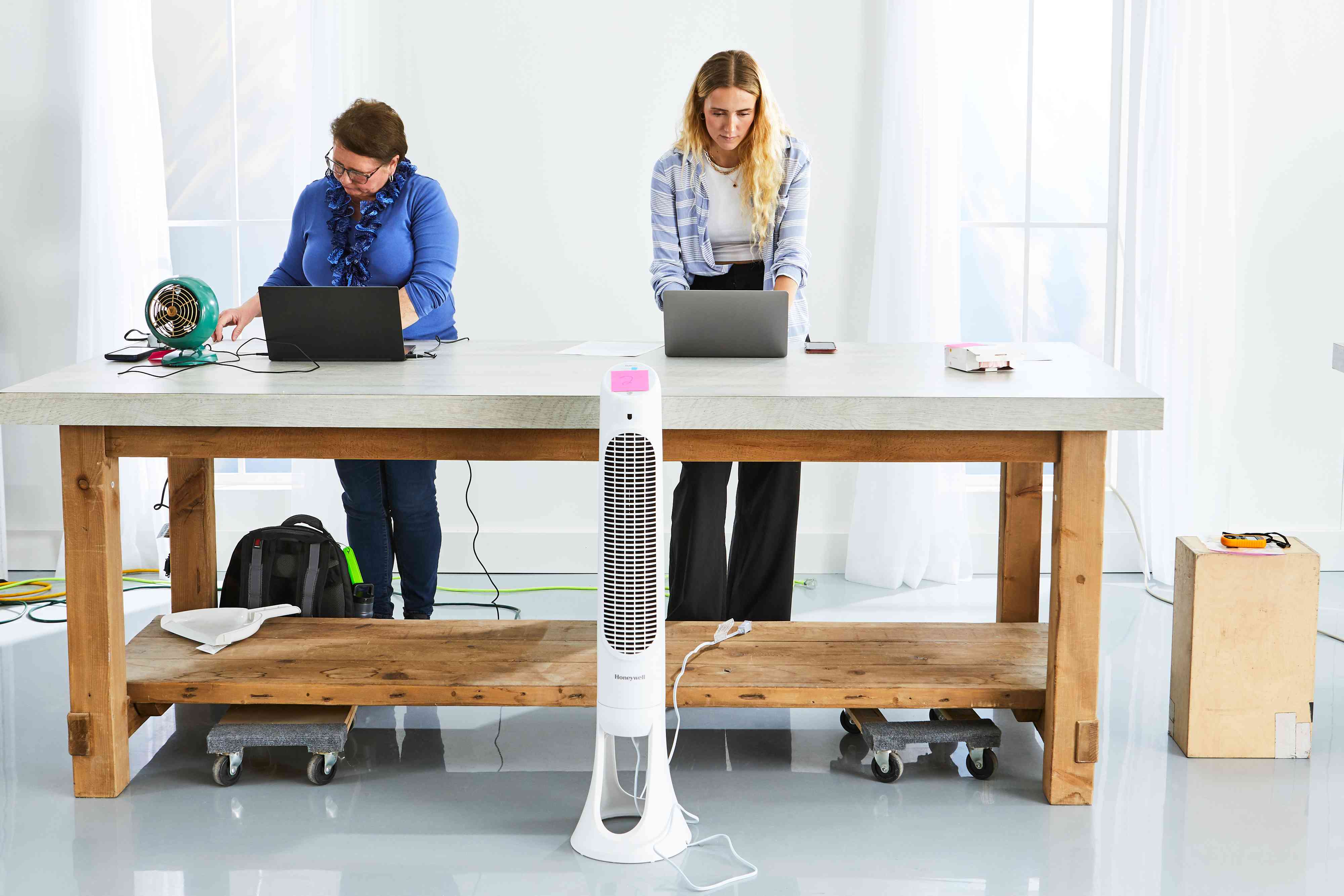 Two people testing out fans including the Honeywell QuietSet Whole Room Tower Fan