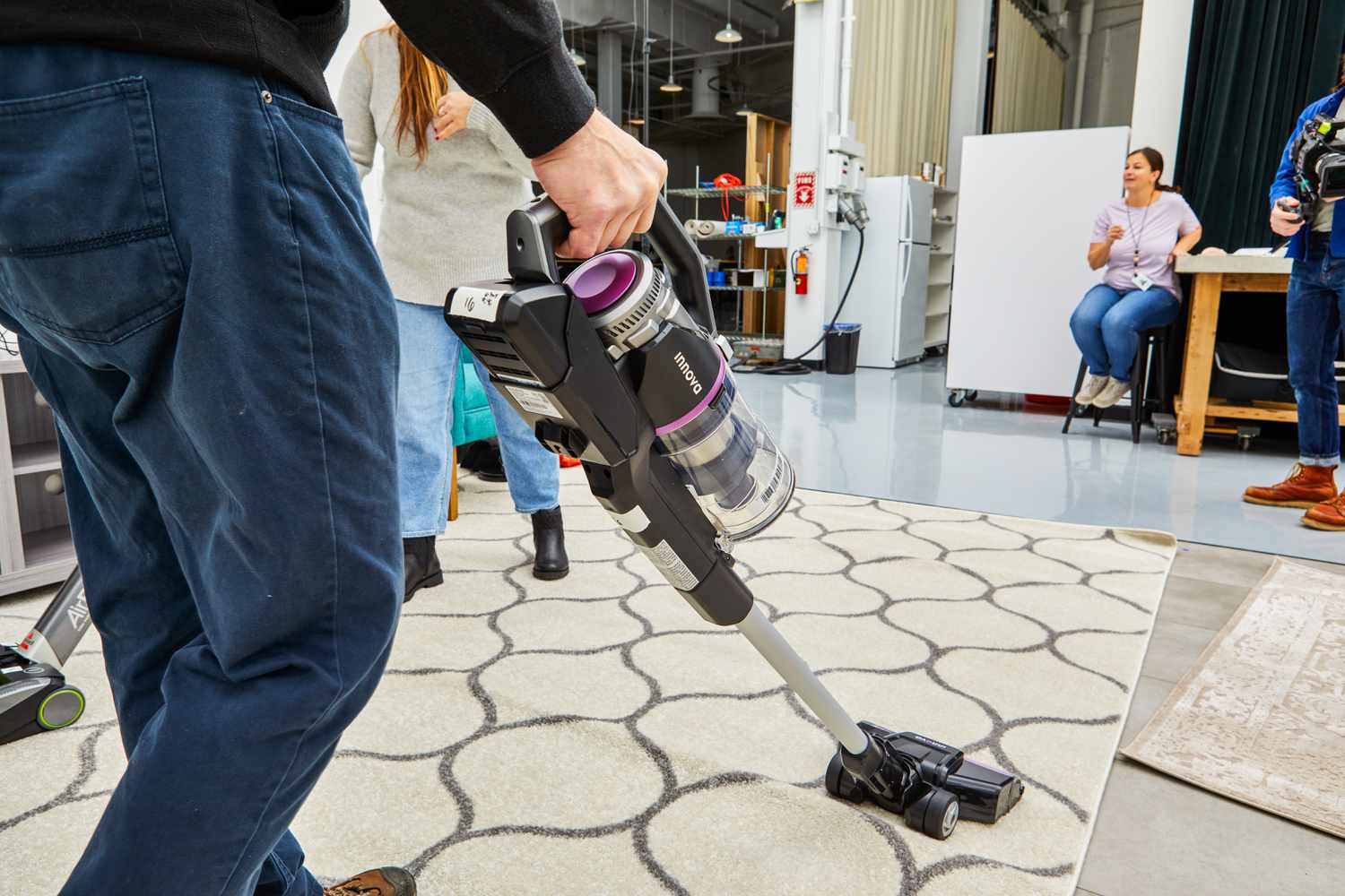 Person cleaning a carpet with the Innova Cordless Stick Multi-Surface Vacuum