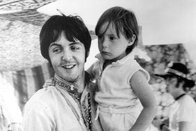 Beatles singer and bass player Paul McCartney holds four year old Julian, son of his colleague John Lennon (visible in the background) during a holiday near Athens in Greece. 