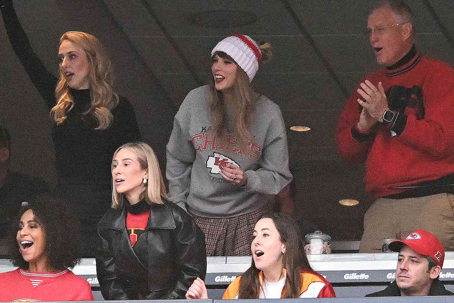 Brittany Mahomes (back row 2nd L), Taylor Swift, and Scott Swift cheer while watching the game between the Kansas City Chiefs and New England Patriots at Gillette Stadium on December 17, 2023 in Foxboro, Massachusetts