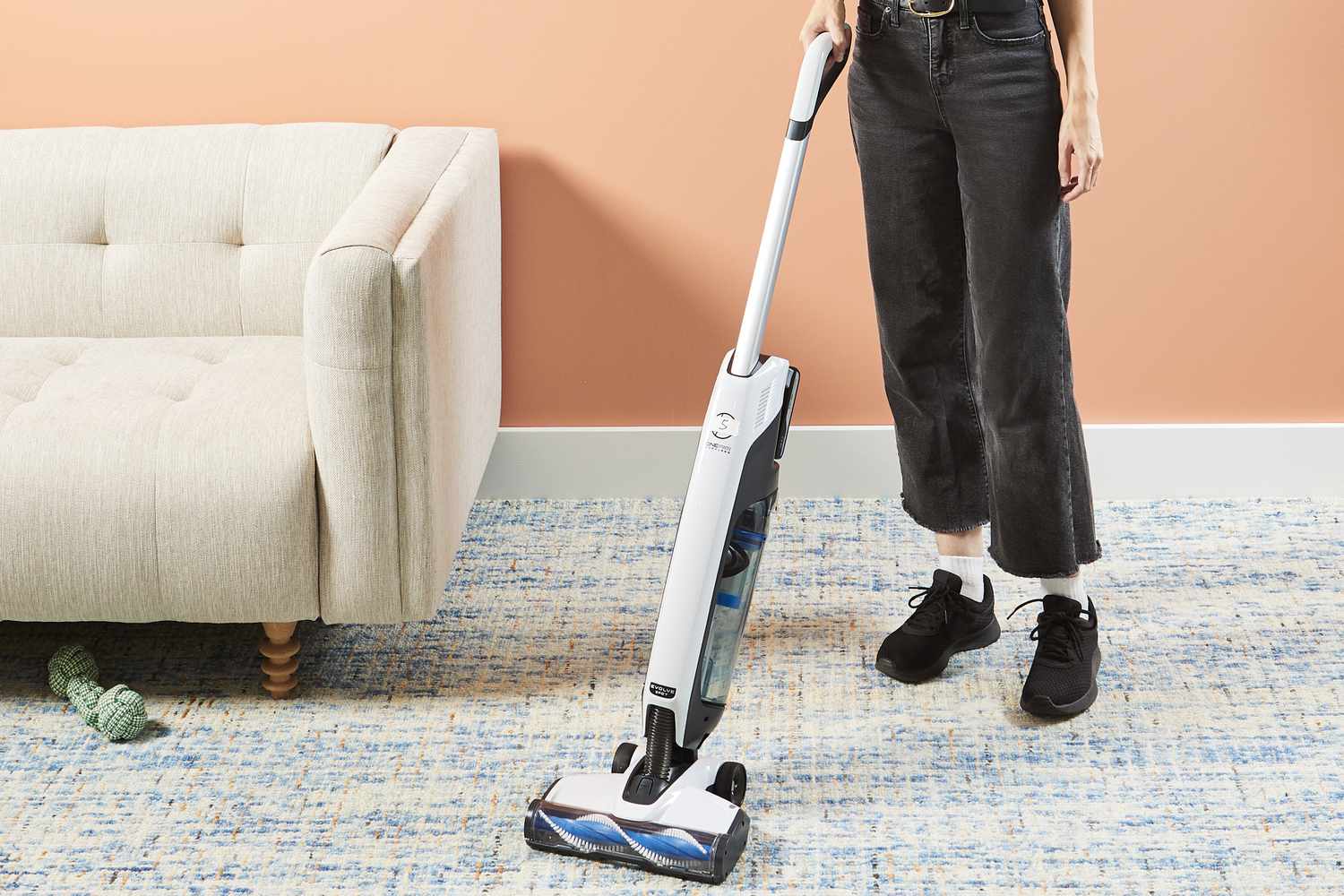 Person using Hoover Onepwr Evolve Pet Cordless Vacuum to clean carpet