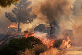 Cars are threatened by flames as the Highland Fire burns in Aguana, California, on October 31, 2023