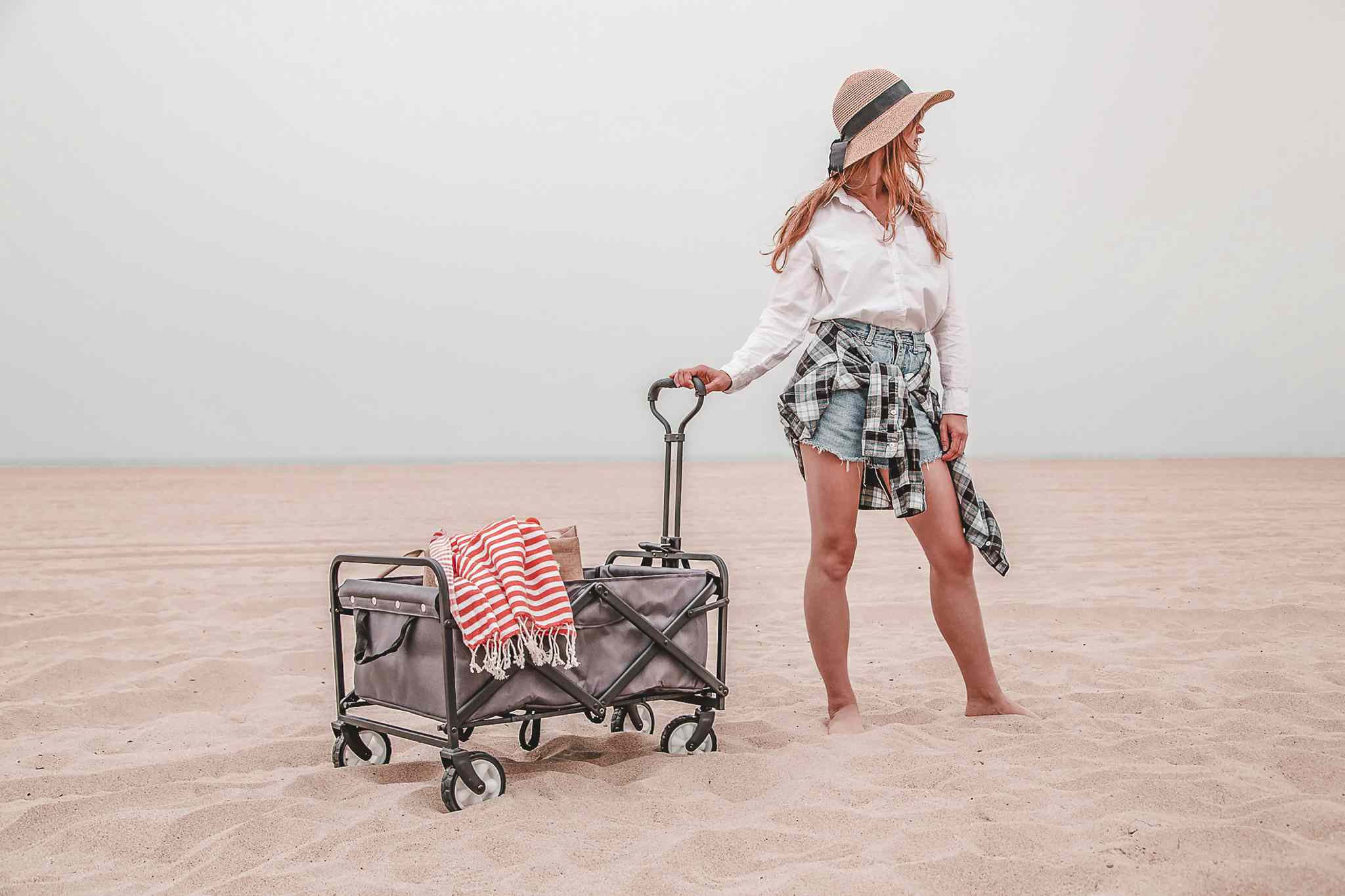 Person standing next to Whitsunday Collapsible Folding Cart displayed on a sandy beach