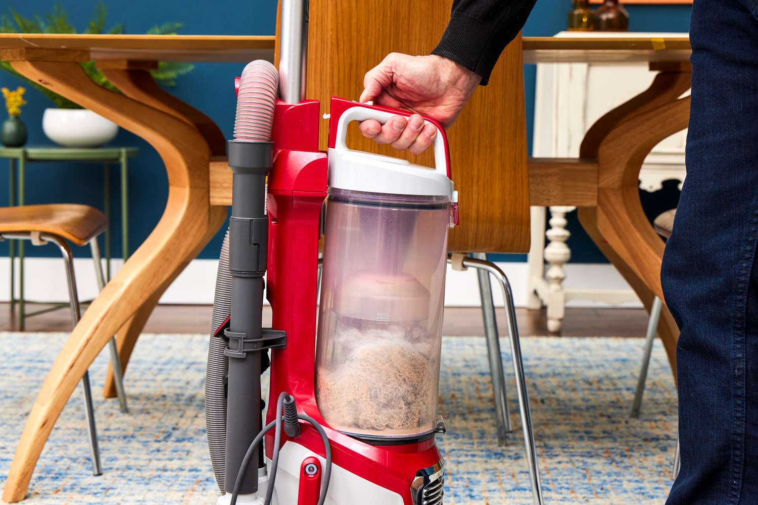 A person detaches the canister from the Kenmore Allergen Seal Bagless Upright Vacuum