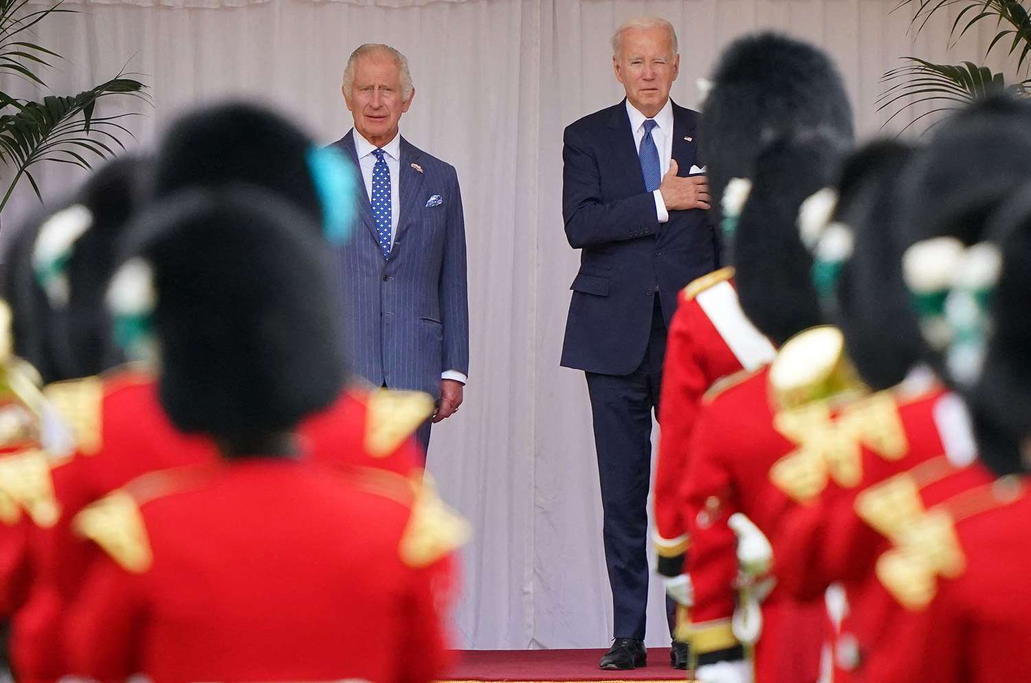 US President Joe Biden and Britain's King Charles III listen to the US national anthem before inspecting a guard of honour, formed by members of the Welsh Guards, during a ceremonial welcome in the Quadrangle at Windsor Castle