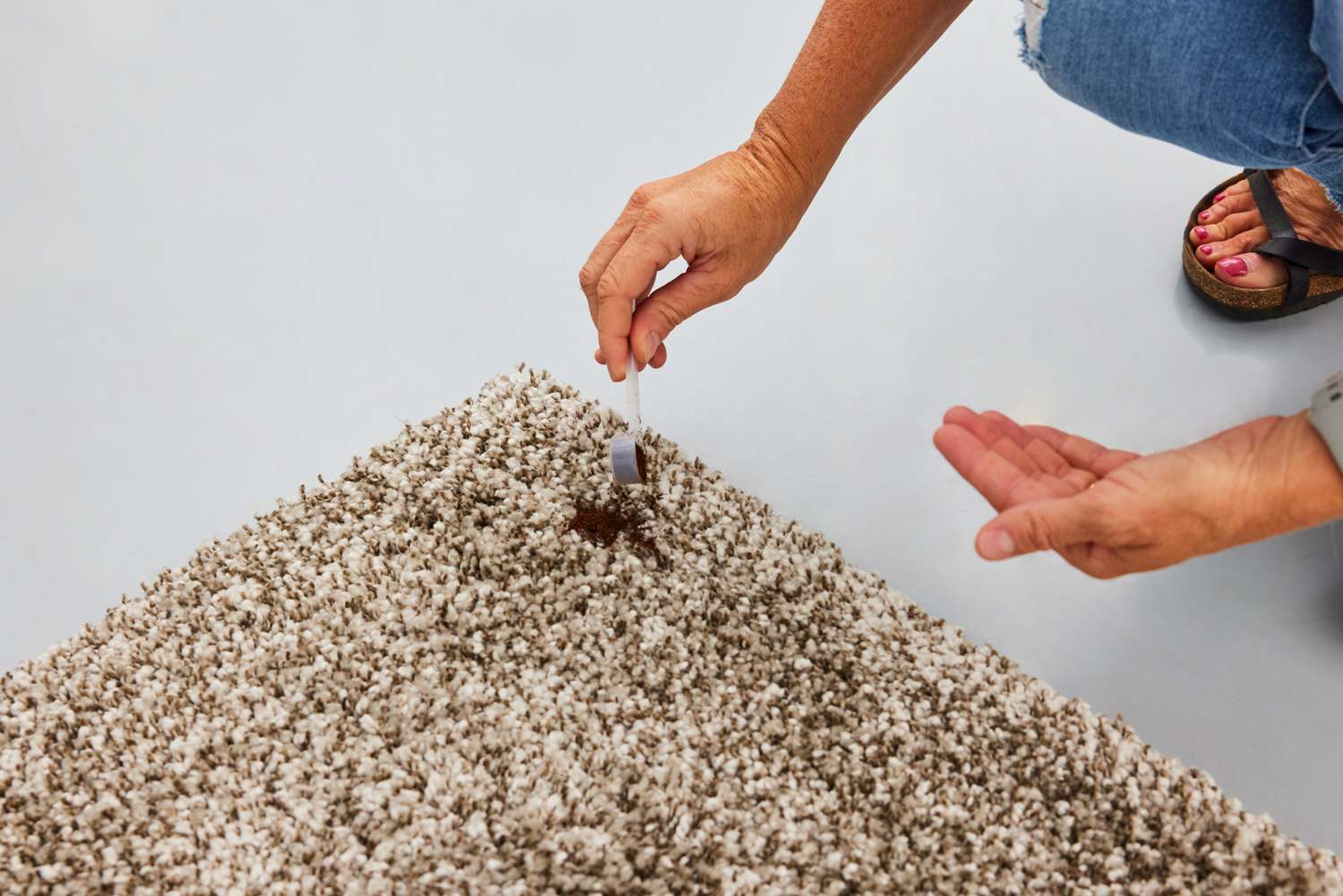 A person pours dirt on the Safavieh Milan Shag Collection Accent Rug