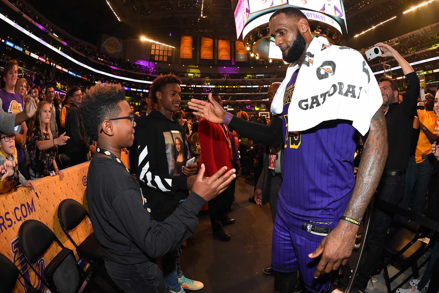 LeBron James #23 of the Los Angeles Lakers is seen shaking hands with his sons Bryce Maximus James and LeBron James Jr. after winning the game against the Utah Jazz on November 23, 2018