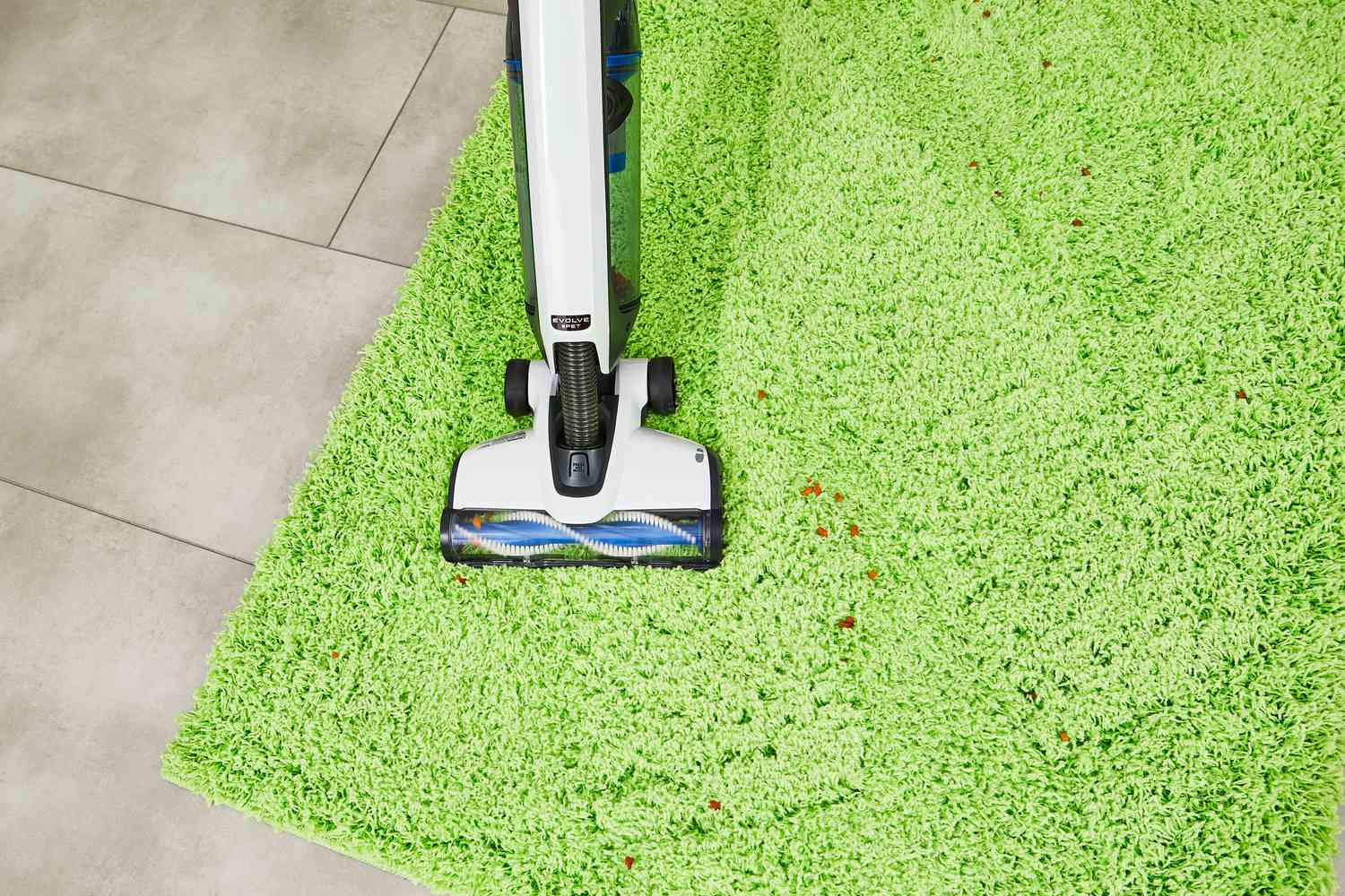 Hoover Onepwr Evolve Pet Cordless Vacuum cleaning food from green carpet