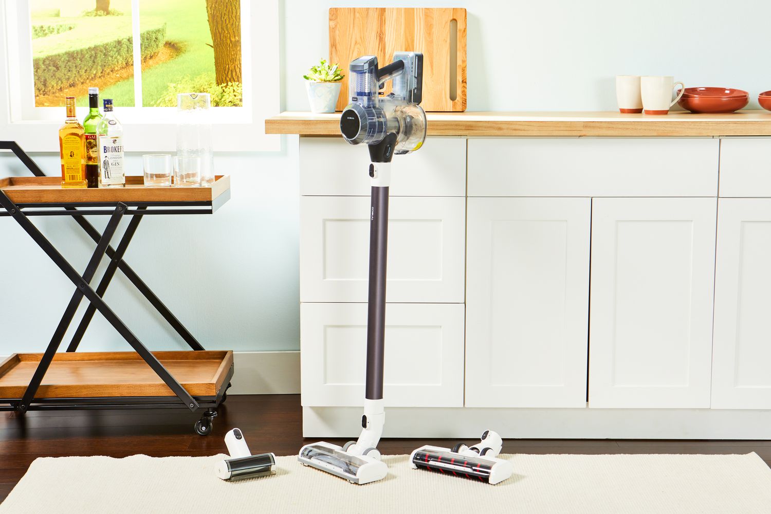 Tineco Pure One S11 Smart Stick/Handheld Vacuum standing next to white countertop and wood standing table