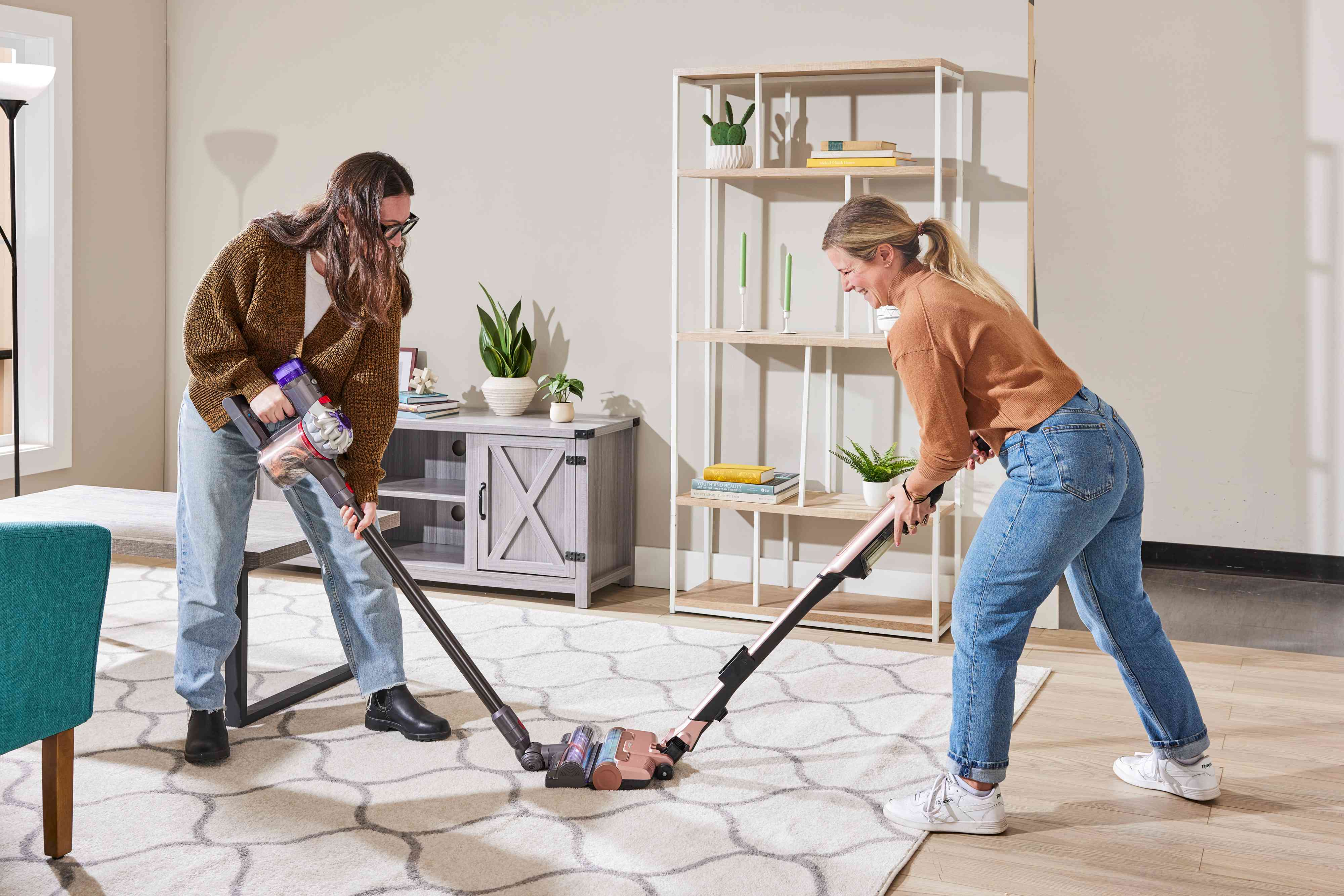 A person cleaning with the Shark Wandvac next to another person vacuuming