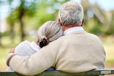 Mature couple cuddling on a park bench