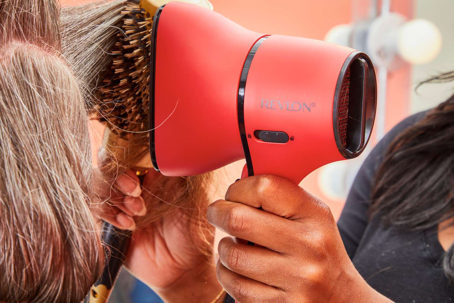 Closeup of a person using the Revlon Airflow Control Dryer to dry another person's hair.