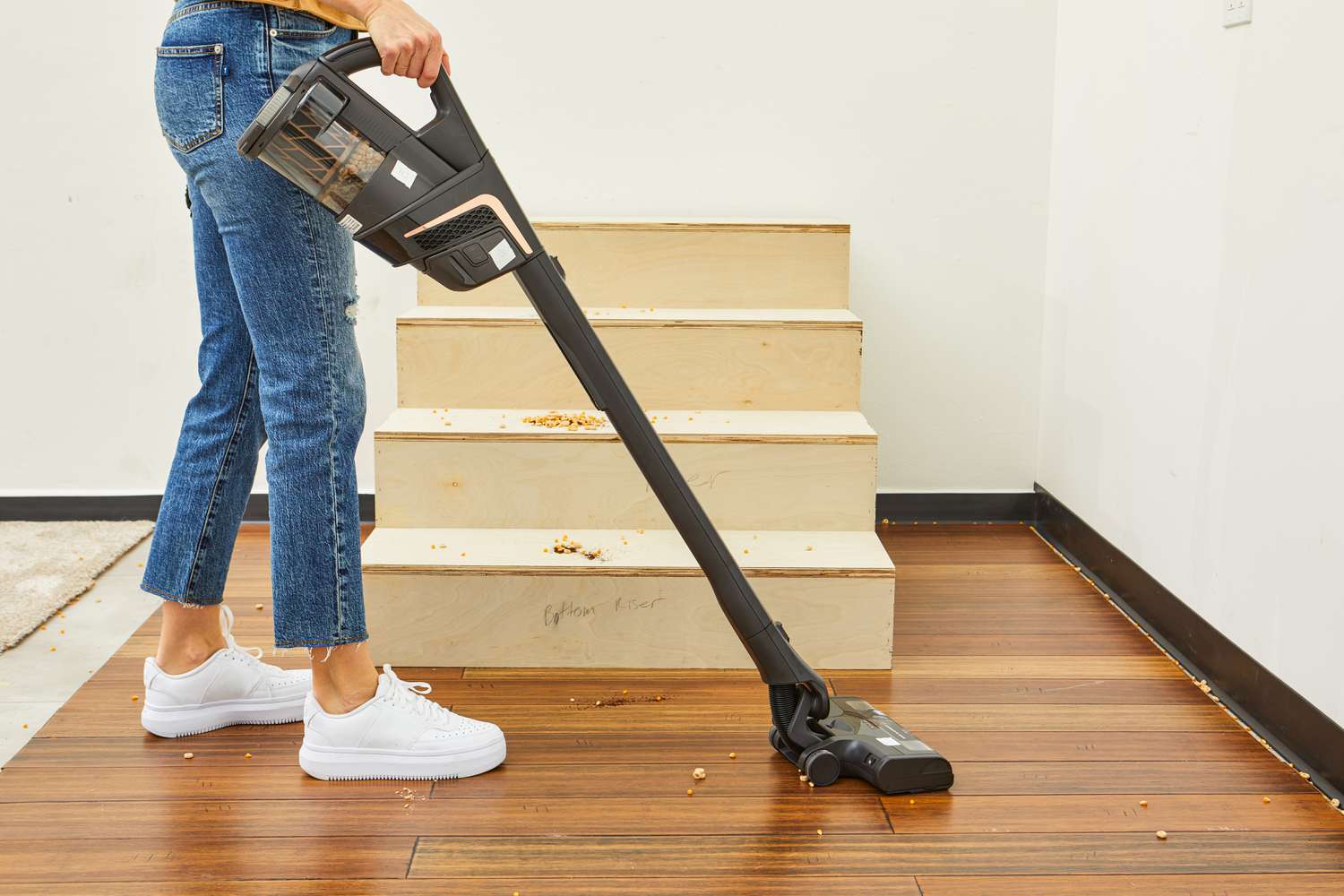 Person cleaning wooden flooring with a Miele Triflex HX2 Cat & Dog Vacuum next to wooden steps 