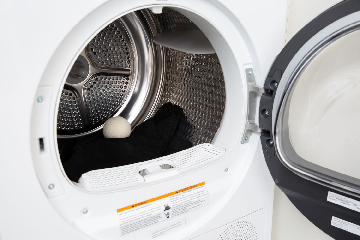 Smart Sheep Dryer Ball displayed inside a front-loading dryer on top of a dark pair of pants