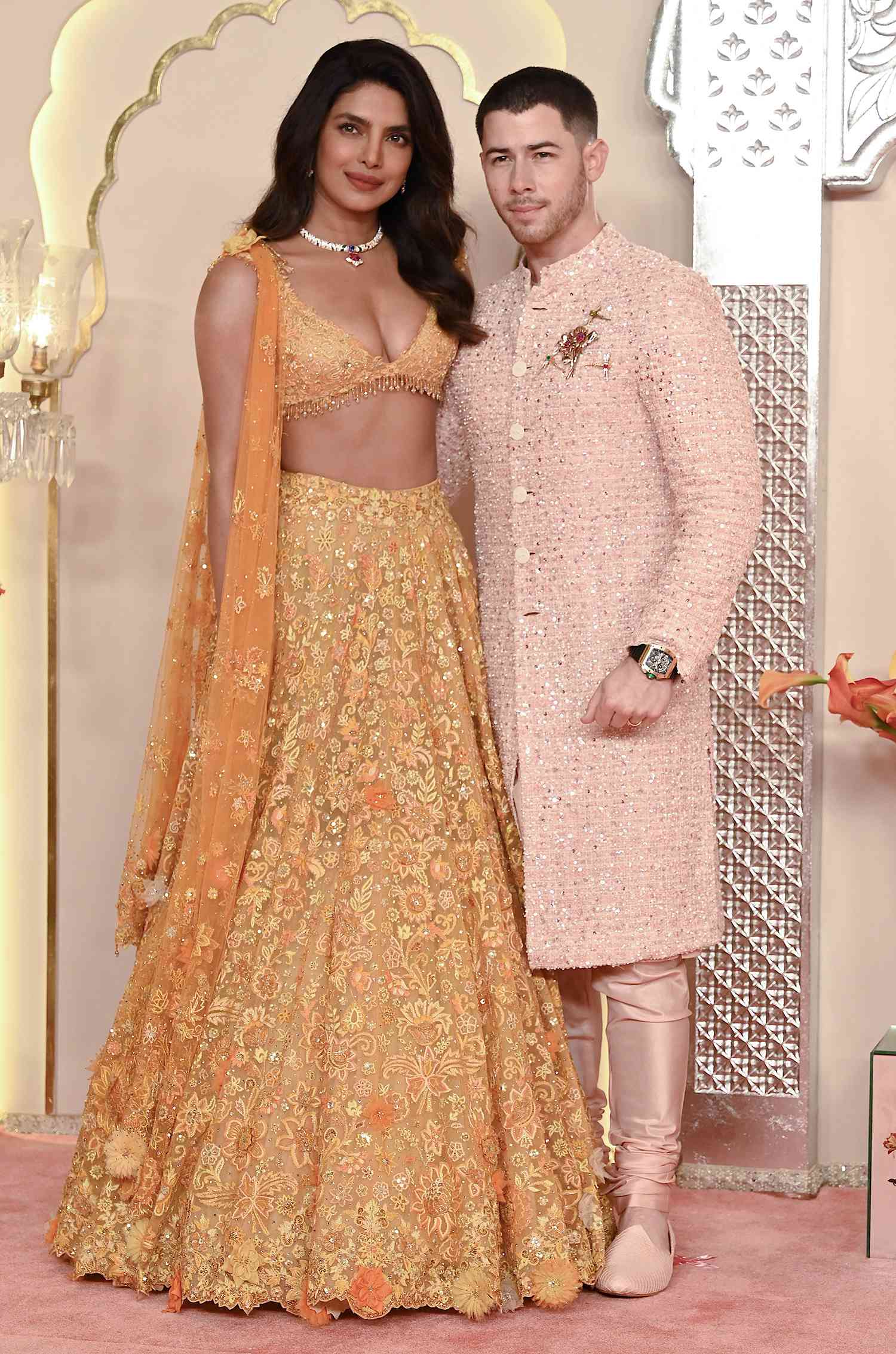 Priyanka Chopra Jonas (L) and her husband American singer-songwriter and actor Nick Jonas (R) pose for photos as they arrive to attend the wedding ceremony of billionaire tycoon and Chairman of Reliance Industries Mukesh Ambani's son Anant Ambani and Radhika Merchant in Mumbai 