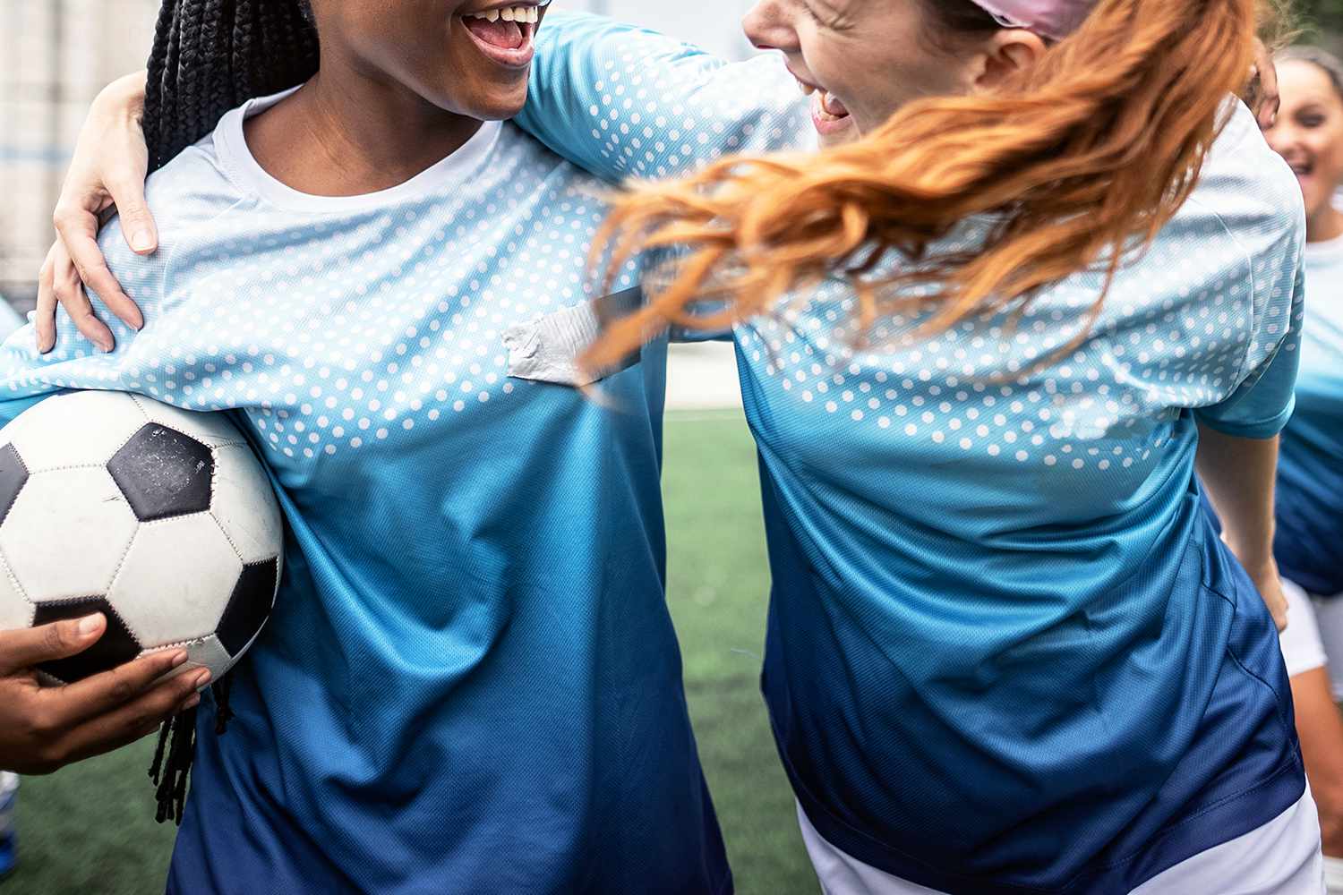 Happy female team walking in the soccer field