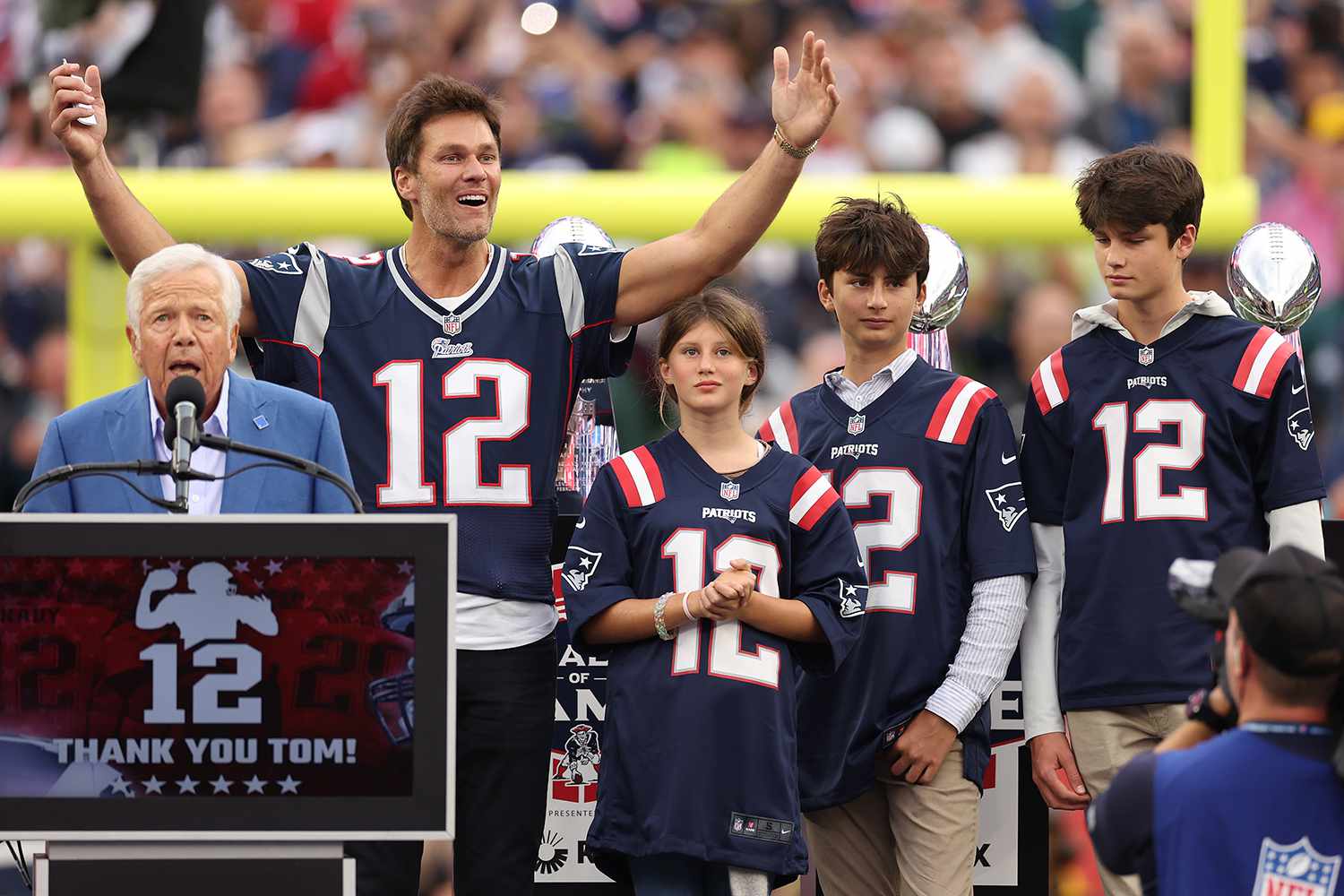 New England Patriots owner Robert Kraft speaks while former New England Patriots quarterback Tom Brady reacts while Brady's children, Vivian, Benjamin, and Jack, look on during a ceremony honoring Brady at halftime of New England's game against the Philadelphia Eagles