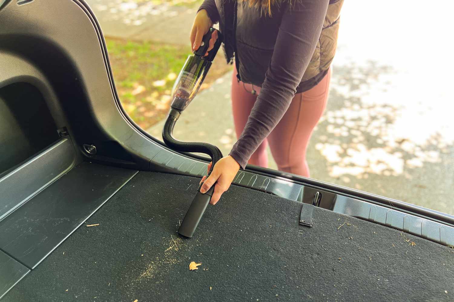A person using the Lipuws Mini to vacuum their car