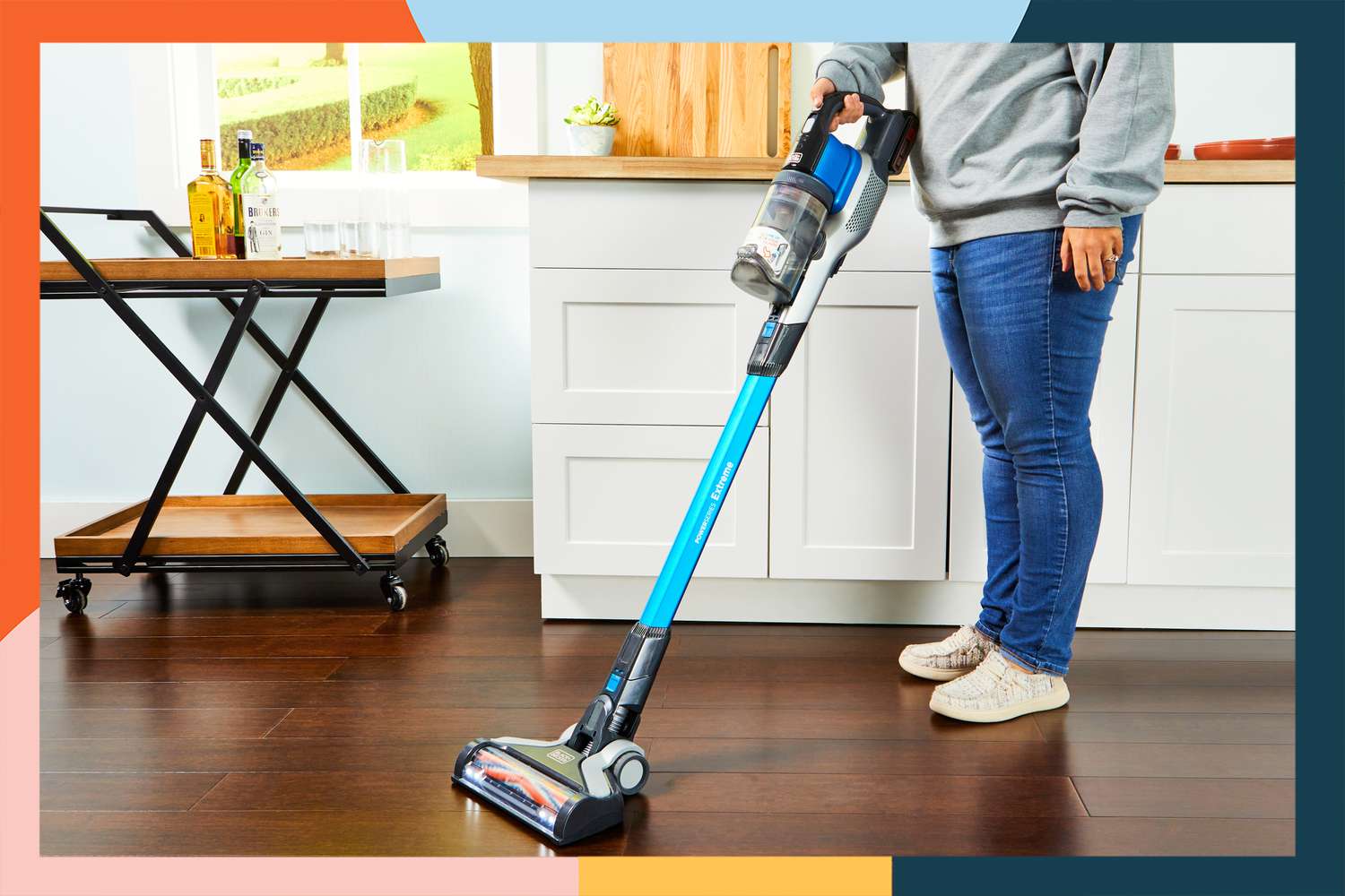Person vacuuming kitchen floor with the Black + Decker Powerseries Extreme Cordless Stick Vacuum