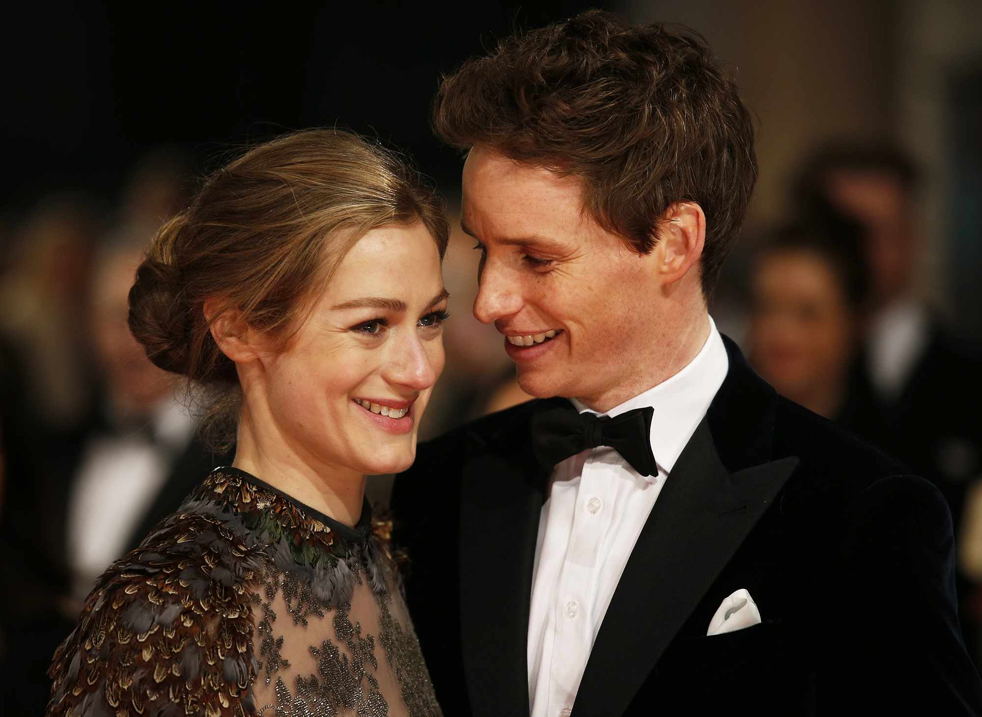 Eddie Redmayne (R) and wife Hannah Bagshawe (L) pose on the red carpet for the BAFTA British Academy Film Awards at the Royal Opera House in London on February 8, 2015