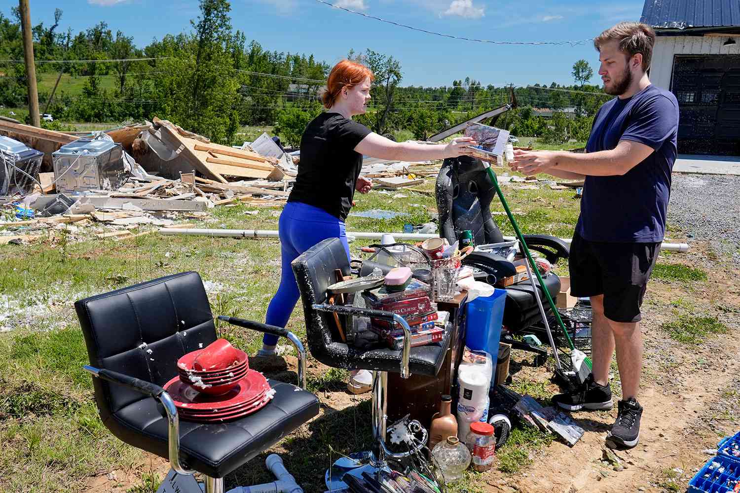 Haley Loukota, left, and her fiance Devin Johnson collect their belongings from storm debris after their home was demolished along Barnsley Loop, Tuesday, May 28, 2024, in Madisonville, Ky. A series of powerful storms hit the central and southern U.S. over the Memorial Day holiday weekend