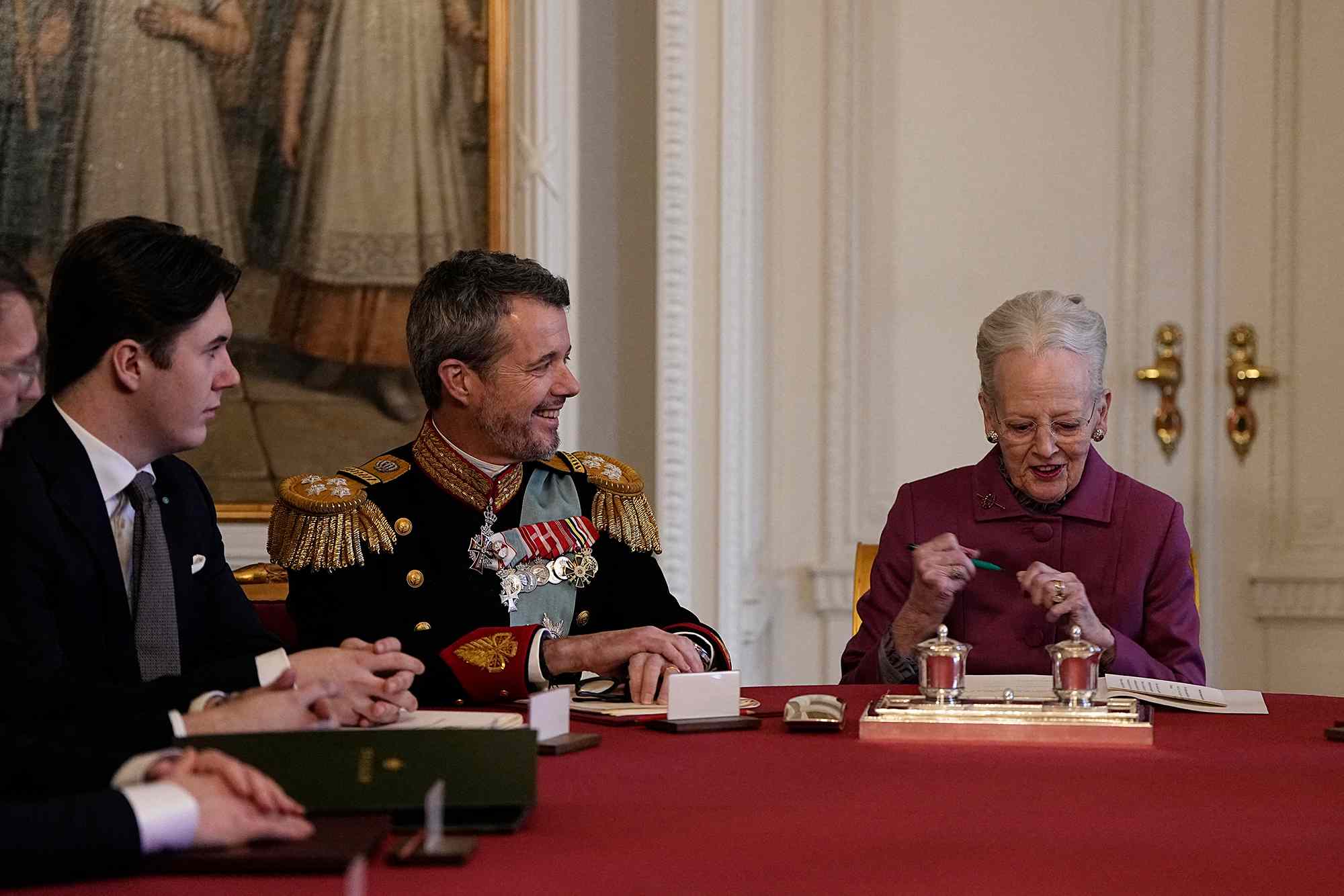 Queen Margrethe II of Denmark (R) signs a declaration of abdication as Crown Prince Frederik of Denmark (C) becomes King Frederik X of Denmark and Prince Christian of Denmark reacts in the Council of State at the Christiansborg Castle in Copenhagen, Denmark