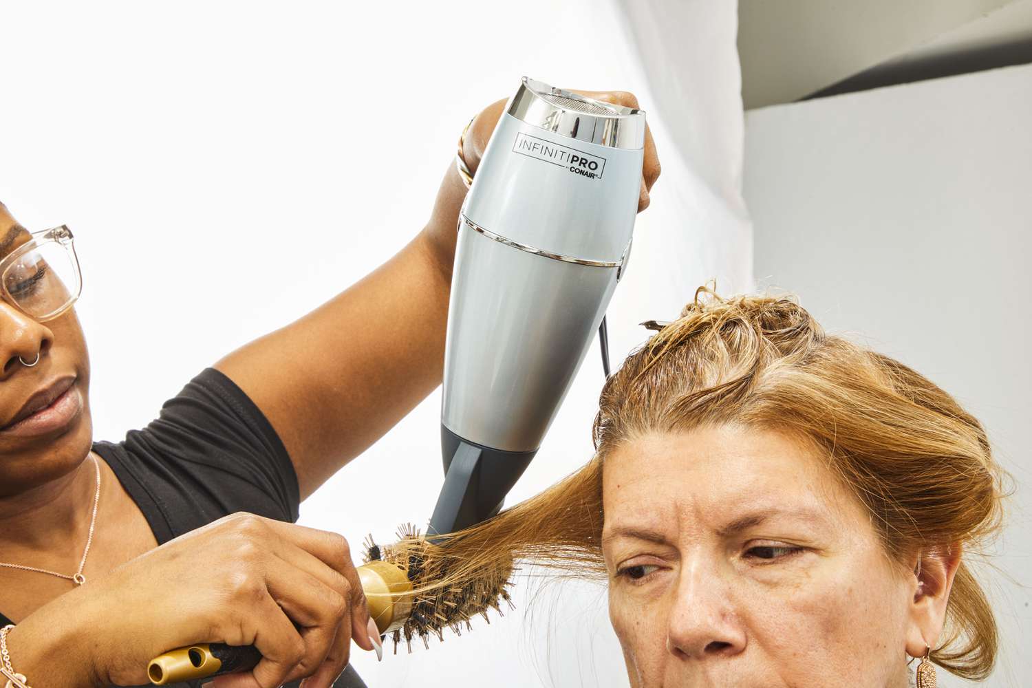 Person blowdrying another person's hair with Conair InfinitiPRO SmoothWrap Hair Dryer