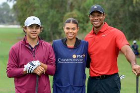 Tiger Woods of The United States poses for a picture on the first tee with his son Charlie Woods and his daughter Sam Woods who was caddying for Tiger during the final round of the PNC Championship at The Ritz-Carlton Golf Club on December 17, 2023 in Orlando, Florida