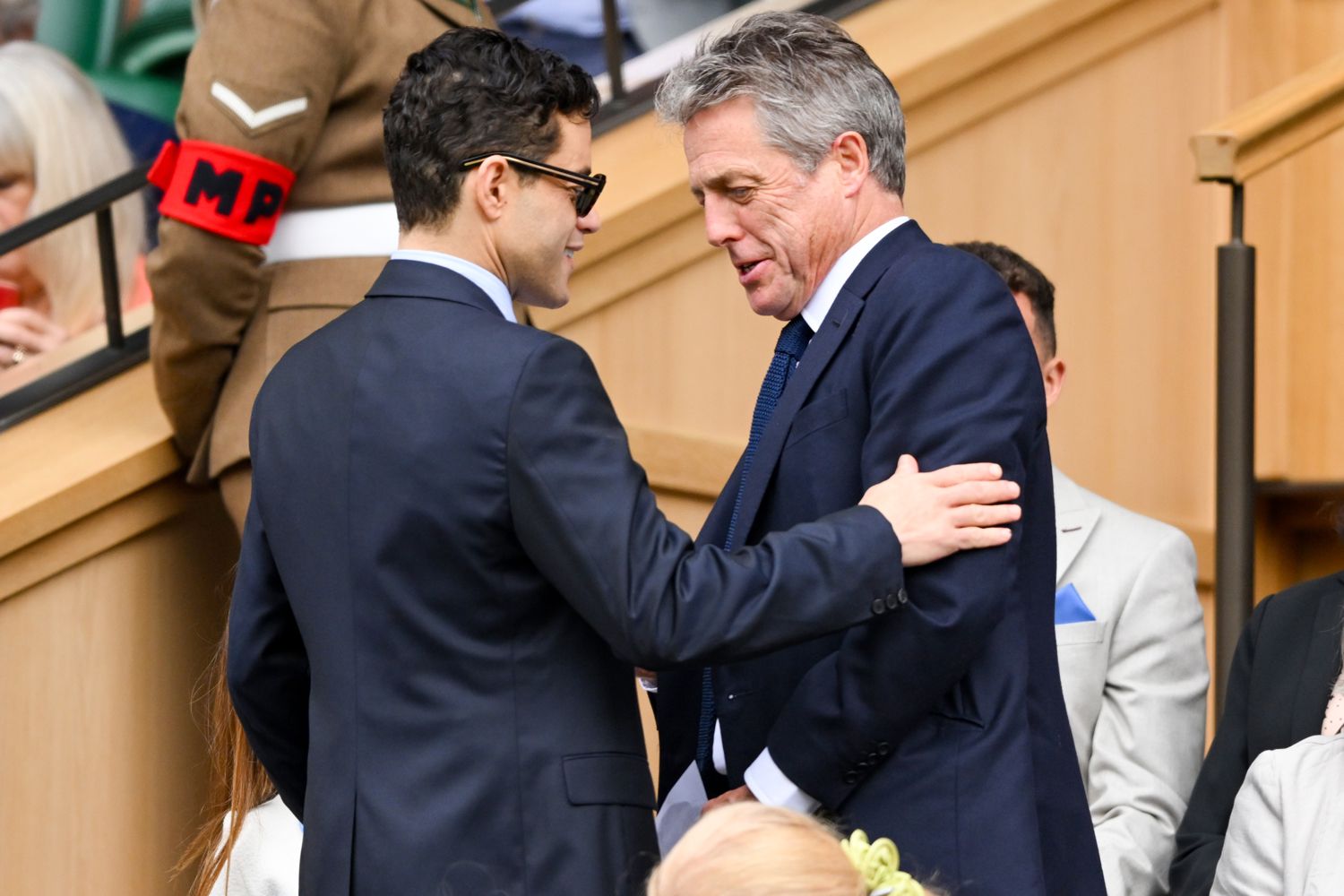 Rami Malek and Hugh Grant court-side of Centre Court on day twelve of the Wimbledon Tennis Championships at the 